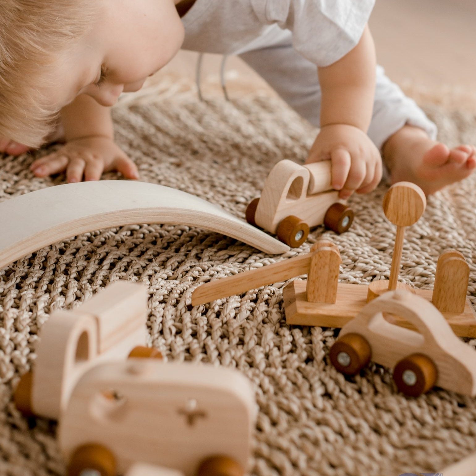 Child playing with wooden toy cars and trucks