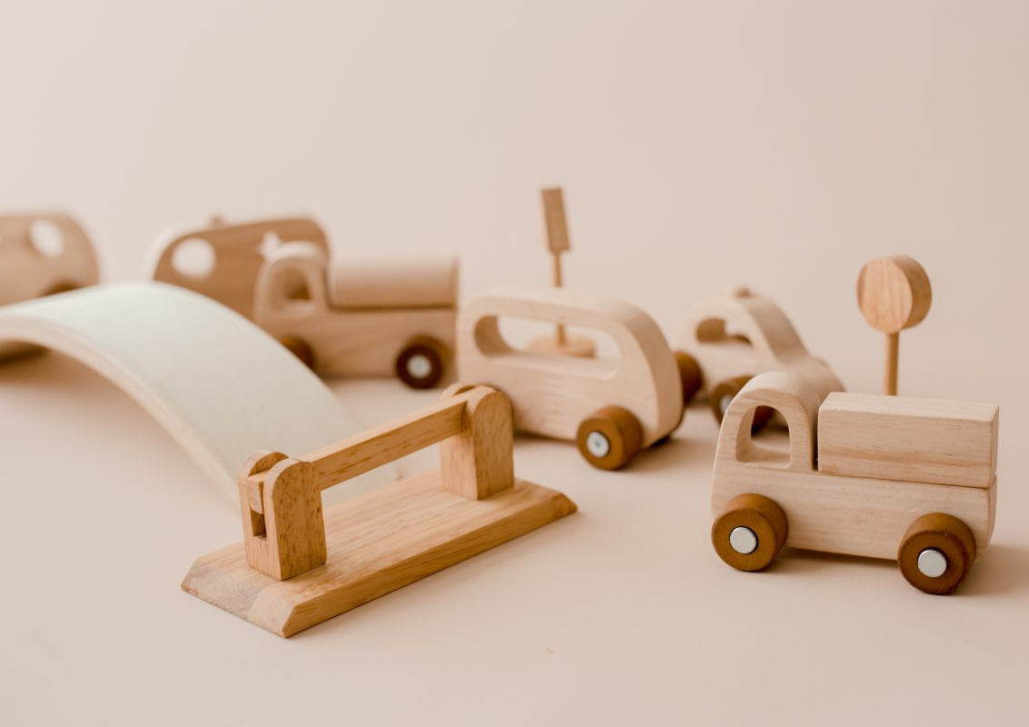 Set of wooden toy cars and trucks on with a bridge and bump gate