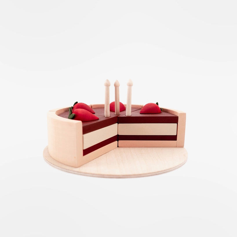 Sabo concept wooden toy layered birthday cake slices with strawberry accents and candles, displayed on a light wood plate