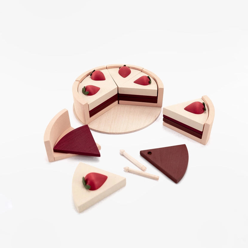 A wooden toy cake, made of light natural wood with chocolate layers and red strawberry details.