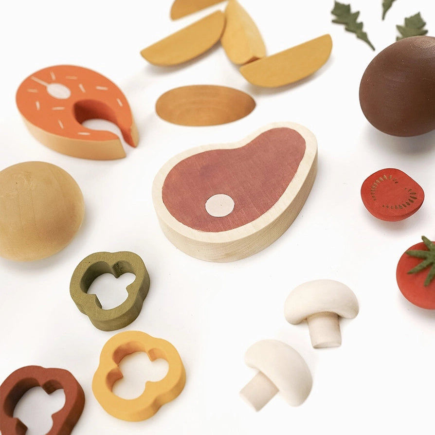 Sabo concept set of wooden toy food dinner pieces  including a steak, vegetables, mushrooms, and a roll.