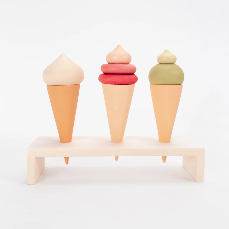 Sabo Concept three wooden toy ice cream cones in pastel colors displayed on a natural wooden stand. 