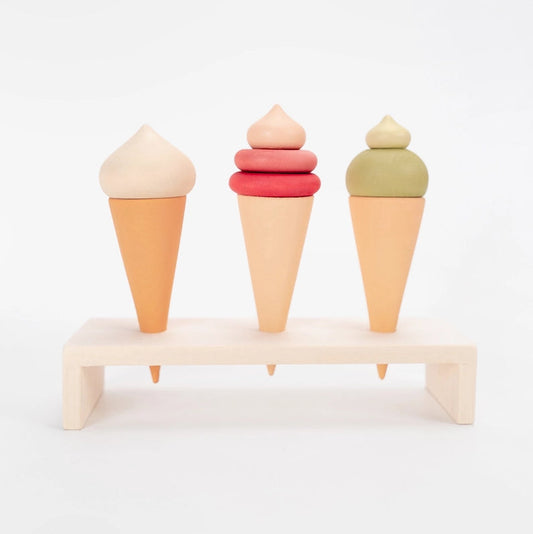 Sabo Concept three wooden toy ice cream cones in pastel colors displayed on a natural wooden stand. 