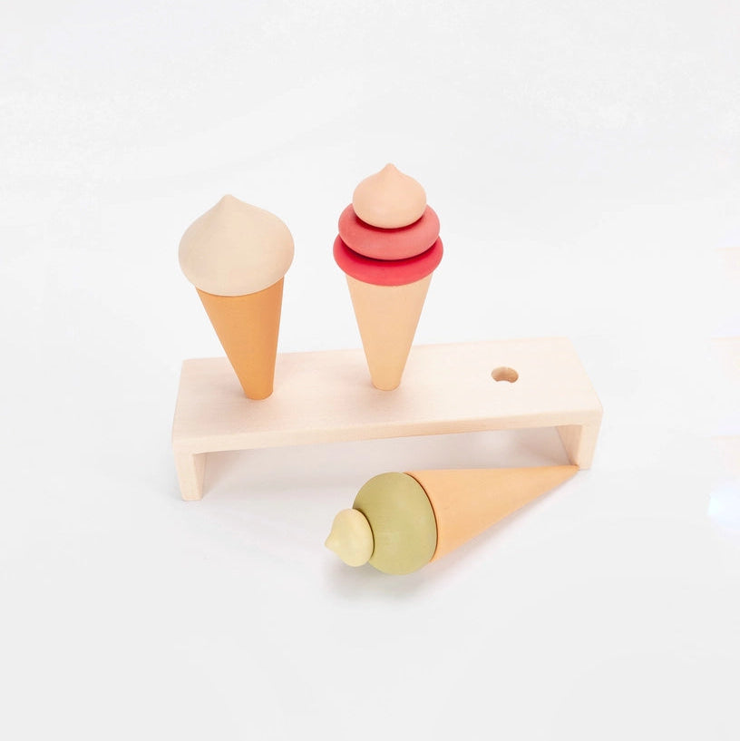 Sabo Concept wooden toy ice cream cones in pink green and white on a natural wood display stand.