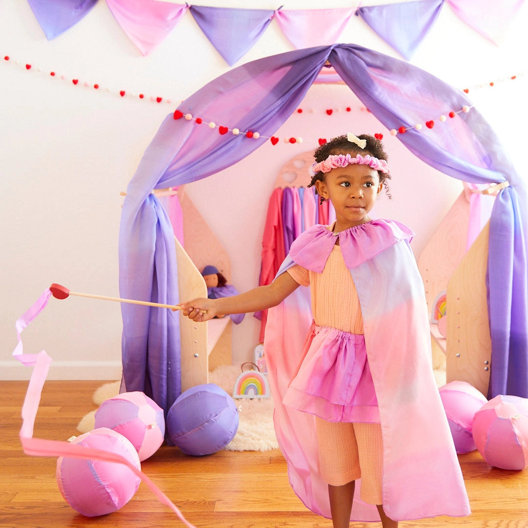 Girl dressed in costume wearing Sarah's Silks Blossom cape. 