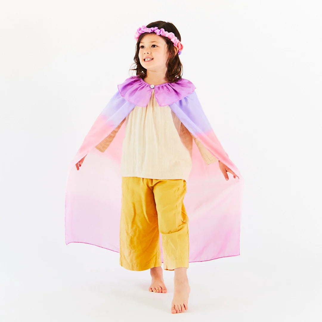 A girl wearing Sarah's Silks Blossom dress-up cape.