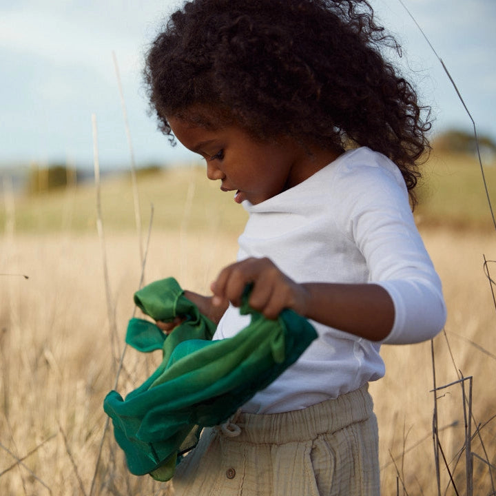 child holding sarah's silks mini forest playsilk