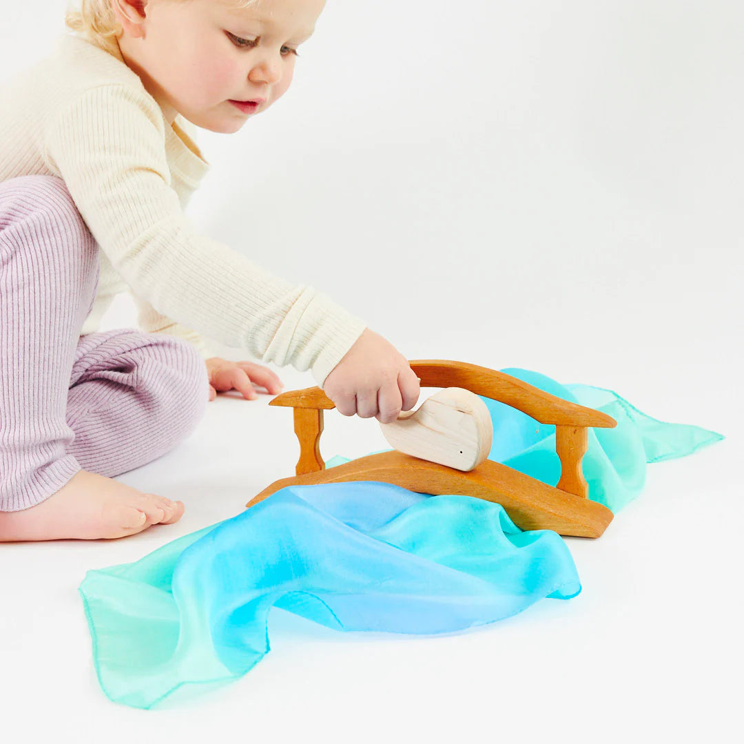 girl playing with sarah's silks mini sea playsilk waldorf toy