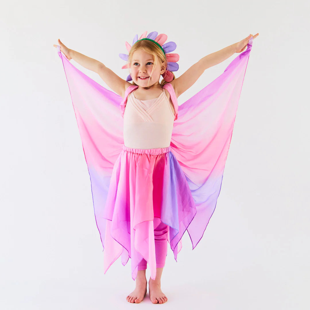 Girl wearing a Sarah's Silks Blossom fairy costume with pink and purple wings and a petal crown.