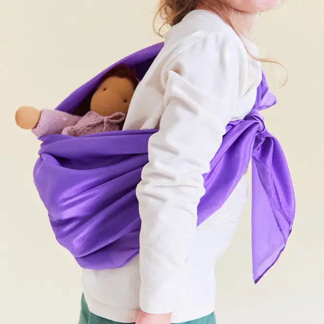 Child using a Sarah's Silks solid purple playsilk as a baby doll carrier.