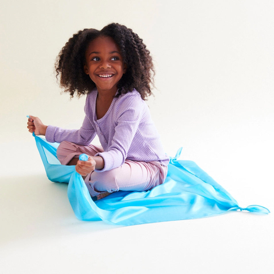Girl playing on a Sarah's Silks sky blue playsilk. 