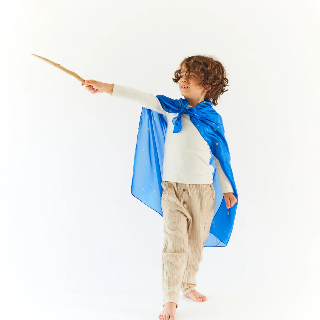 boy wearing a Sarah's Silks starry night playsilk as a wizard's cape and holding a wand
