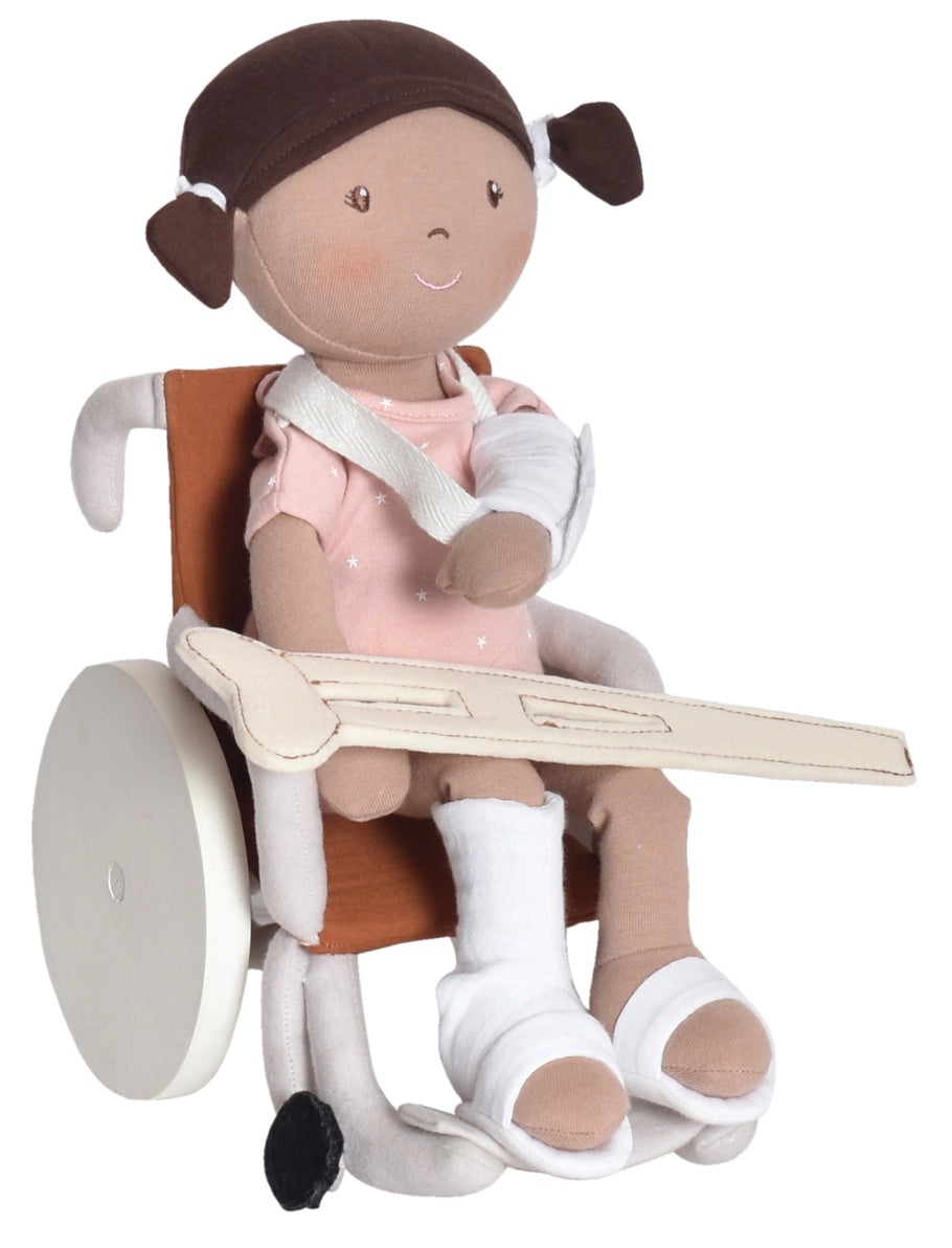 Doll in a toy wheelchair with crutches and casts