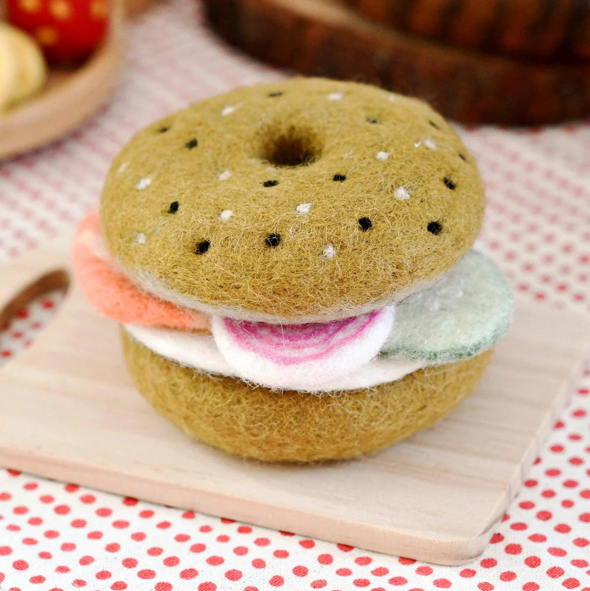 Tara Treasures Felted play food bagel sandwich meal set on a toy wooden cutting board.