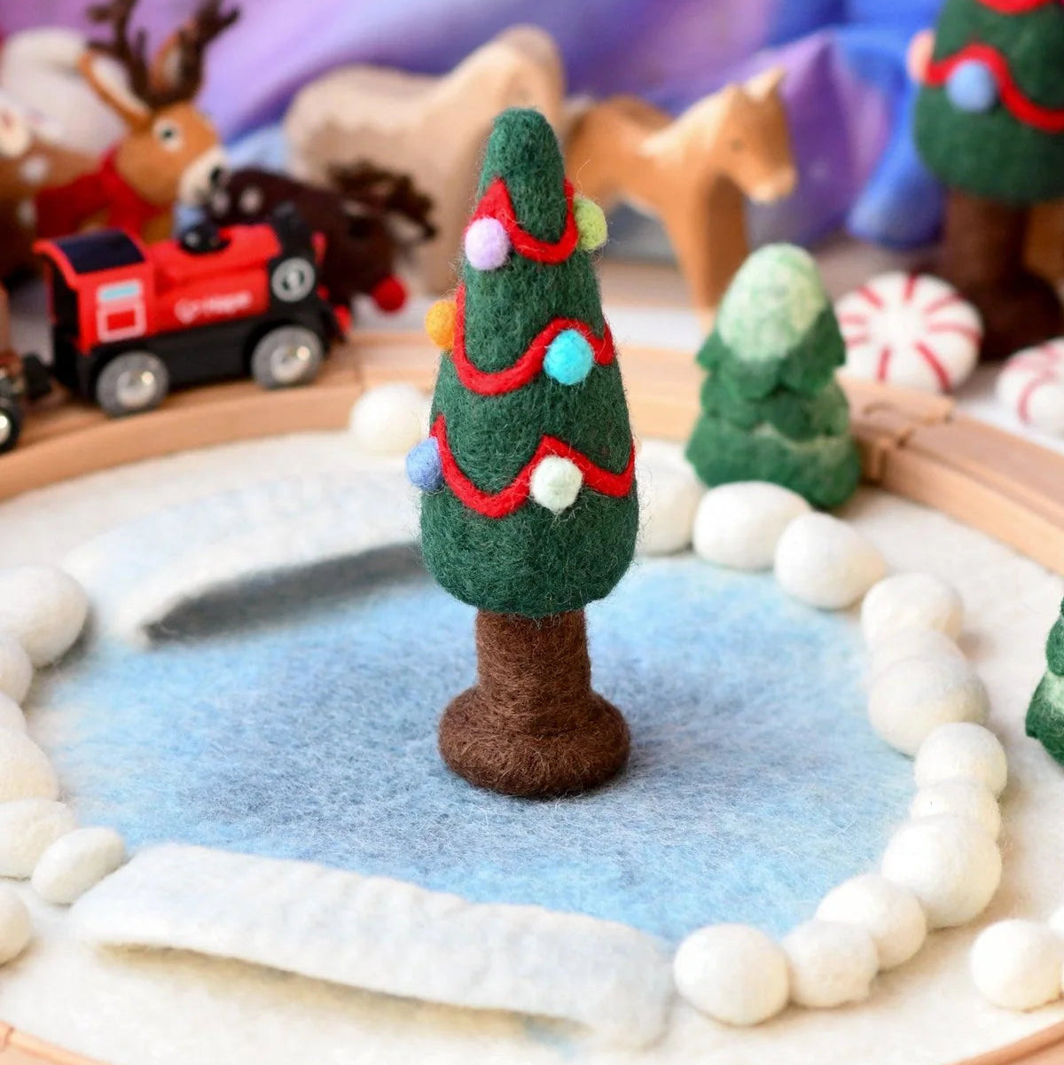 A felt Christmas tree decorated with red felt garlands and colorful felt ornaments.