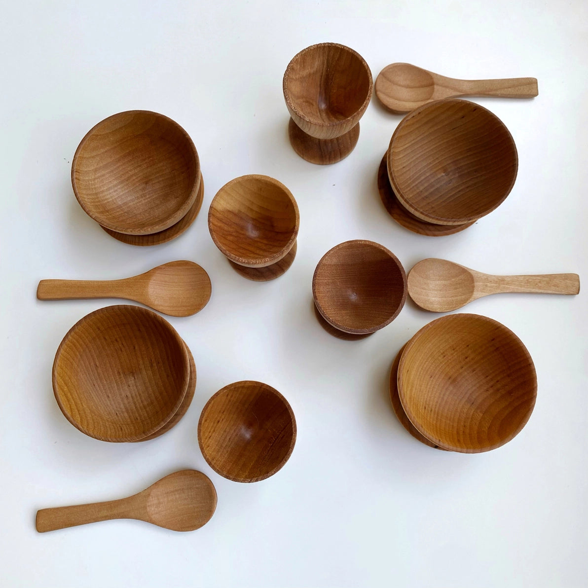 Wooden  dish set toys including plates, bowls and spoons with natural finish.