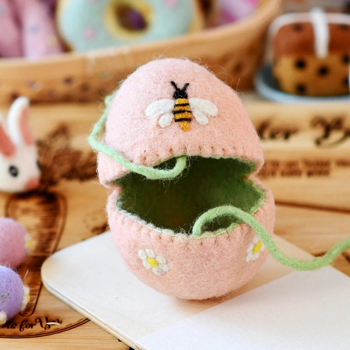 Felt Decorative pink egg cover with a bee and flower design for a child's Easter basket gift. 