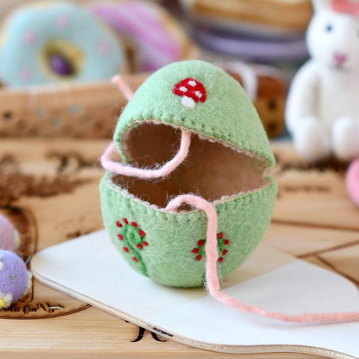 Green felted Easter egg cover with mushroom design for small toy gifts.