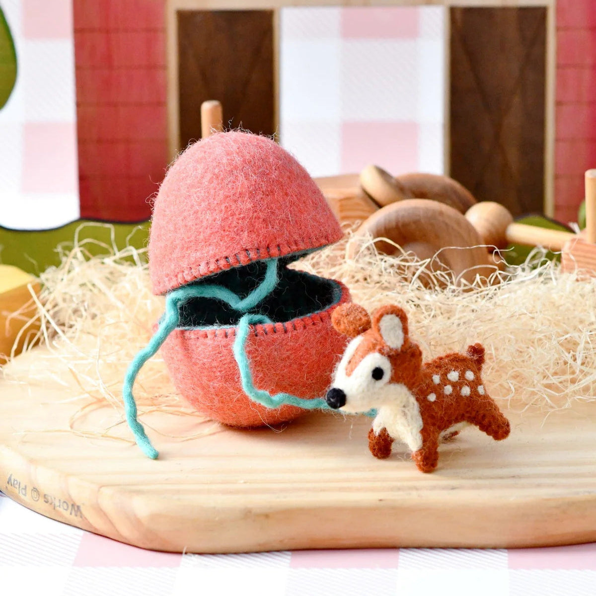 Tara Treasures small world felt deer next to an Easter egg in front of a red barn