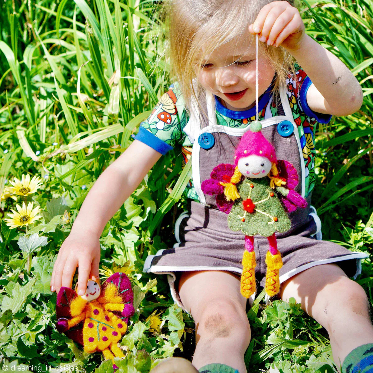 Girl playing with Tara Treasures felted fairy dolls
