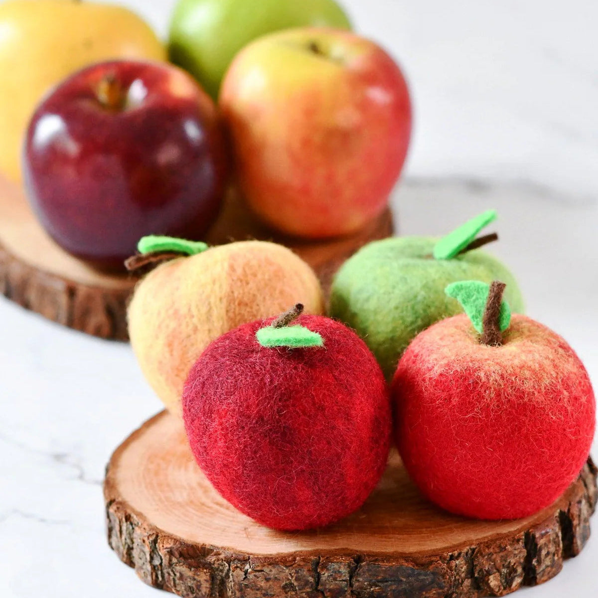 4 Felt play food apples on a wooden stand with real apples in the background