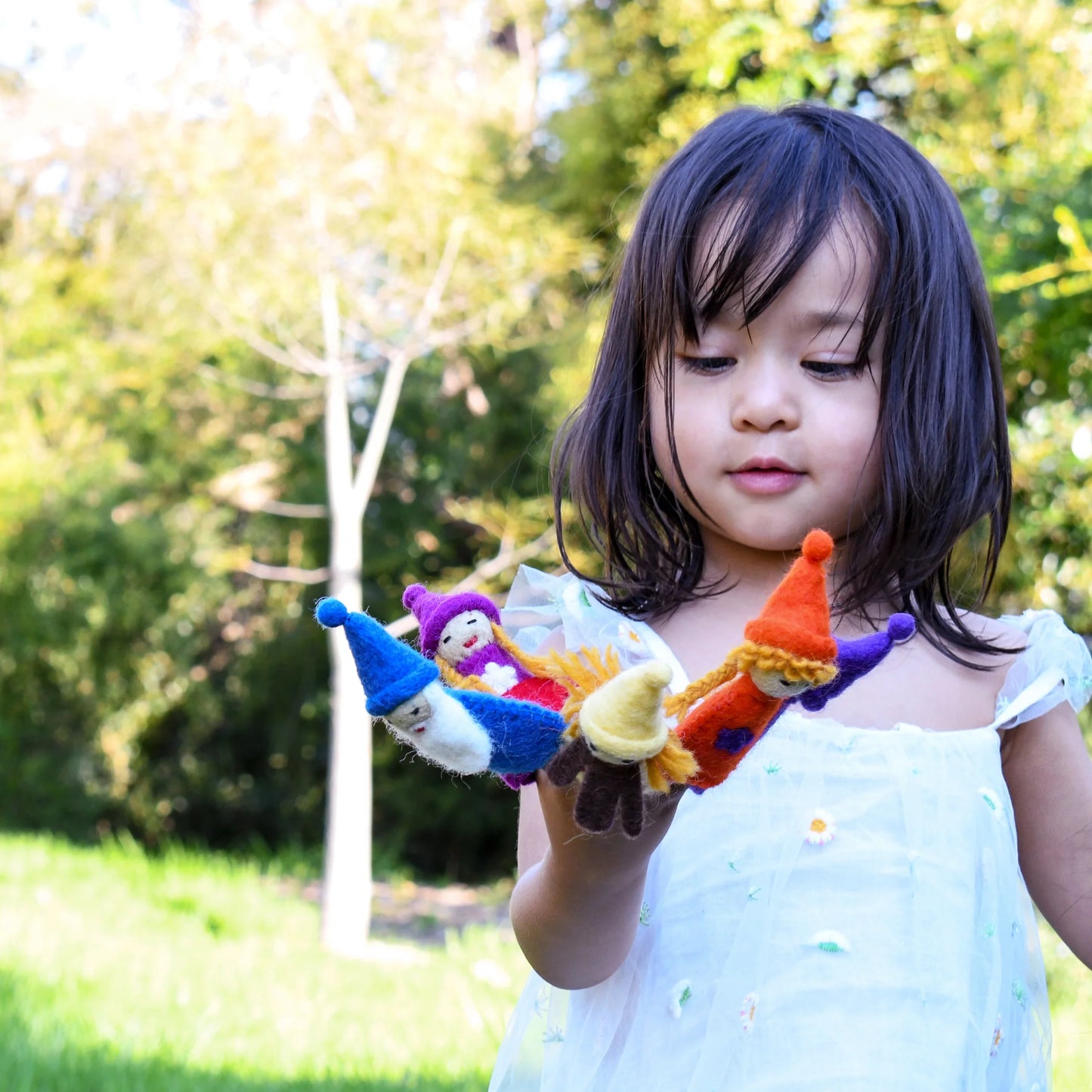 Girl playing with felt rainbow gnome finger puppets