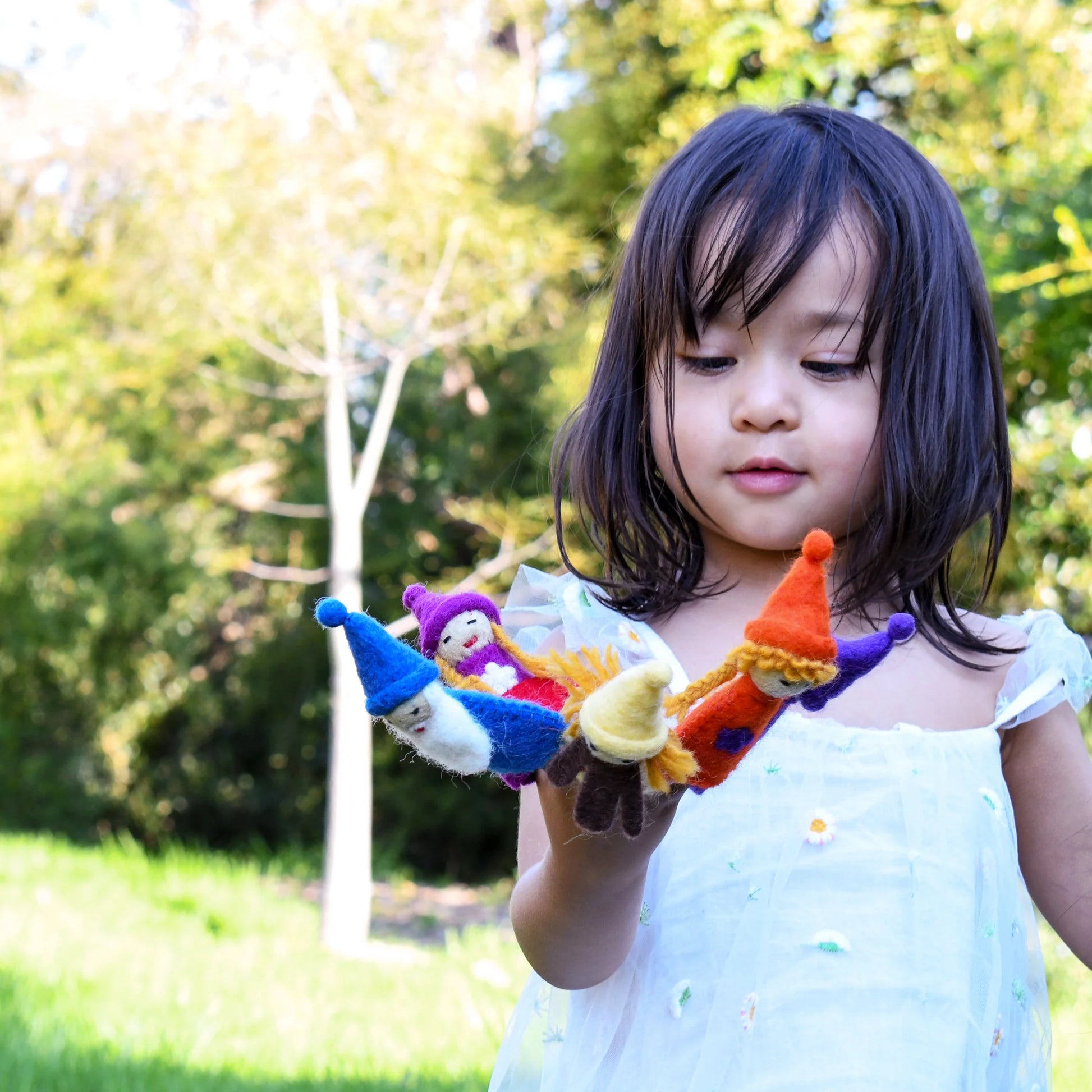 Girl playing with felt rainbow gnome finger puppets