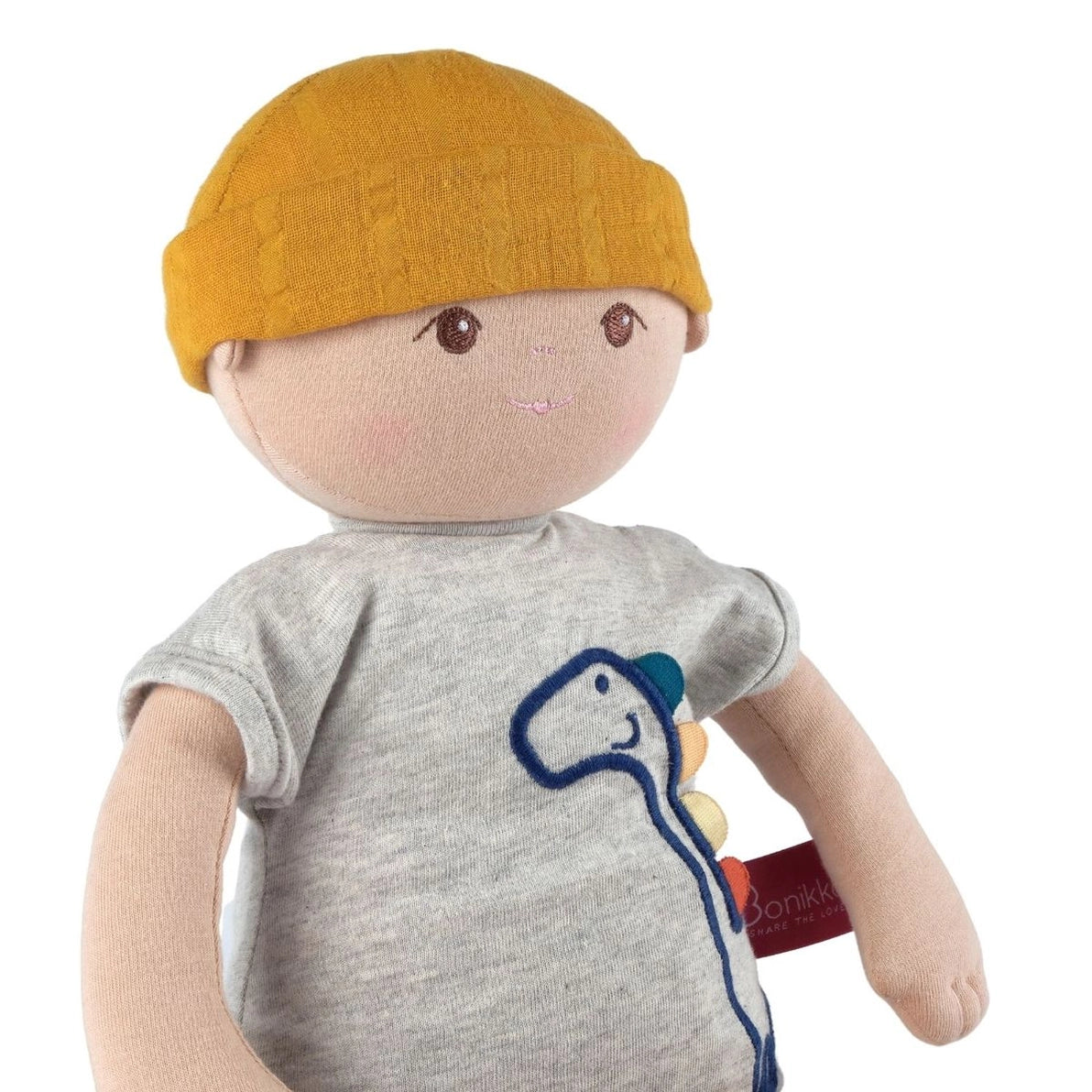 Toy doll with a yellow hat and gray shirt featuring a dinosaur design 