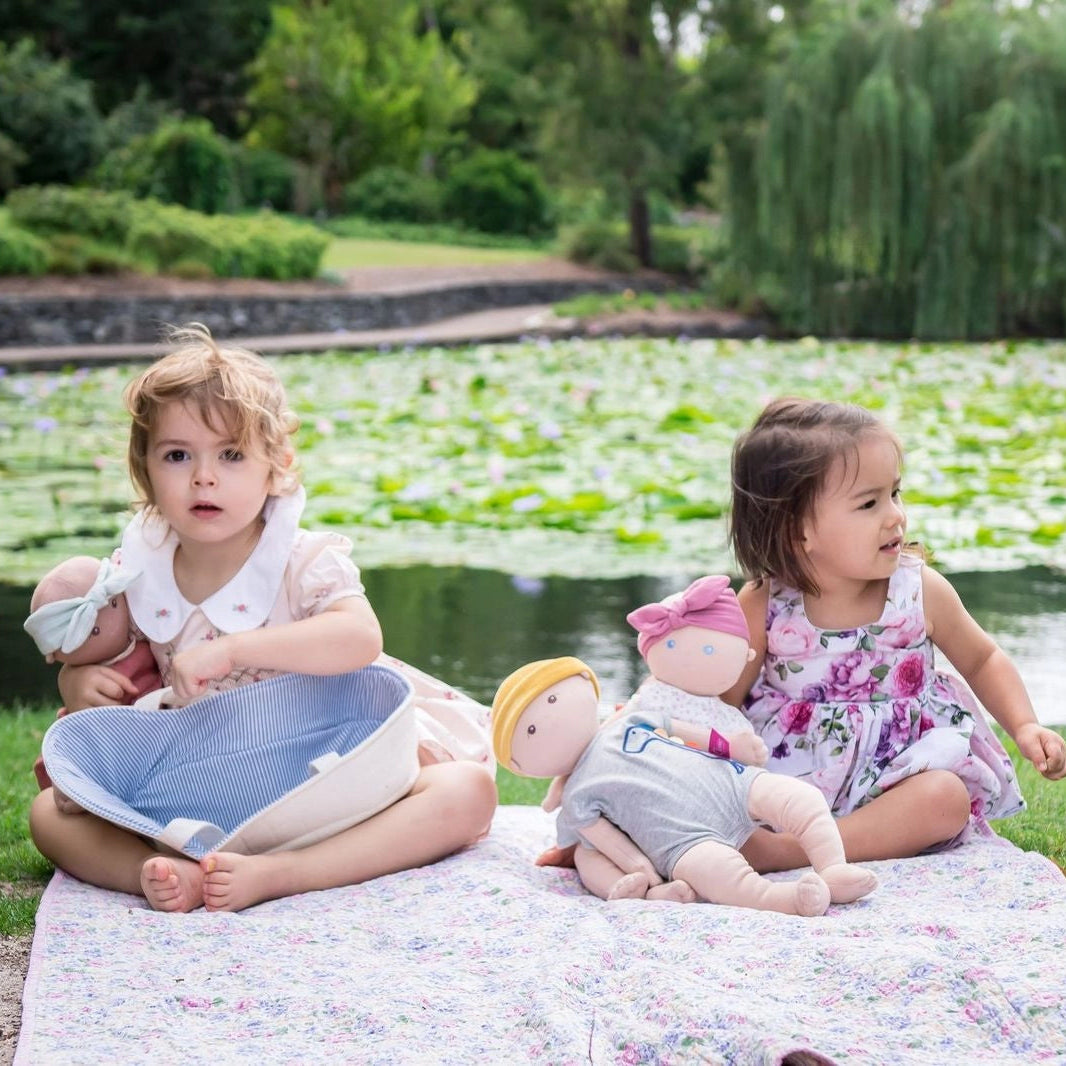 Two children playing with organic baby boy and girl dolls