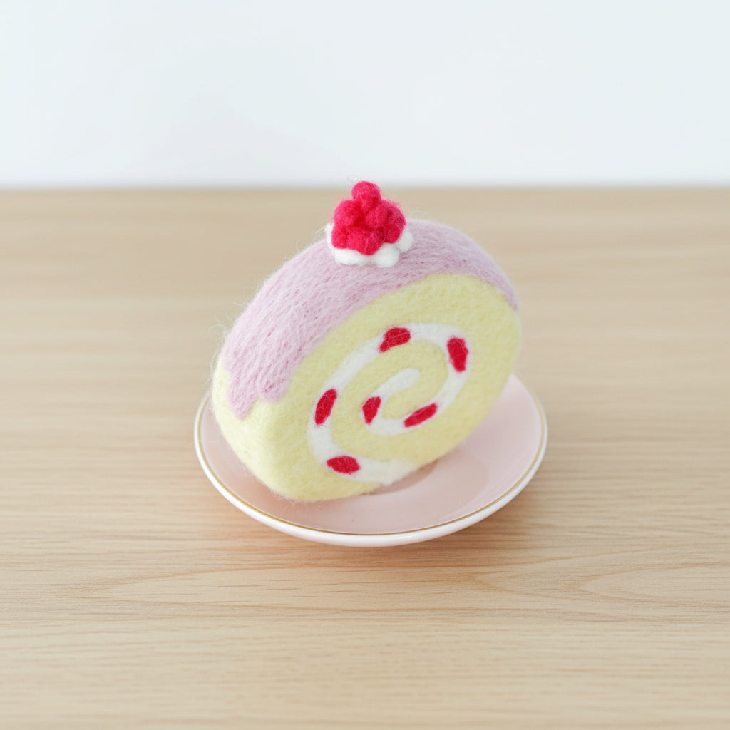 Felt strawberry swiss roll cake toy dessert on a white plate