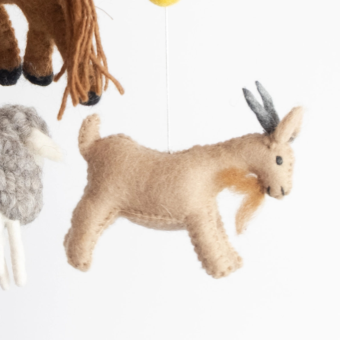 Felted farm animal baby and children's nursery mobile close up of a goat