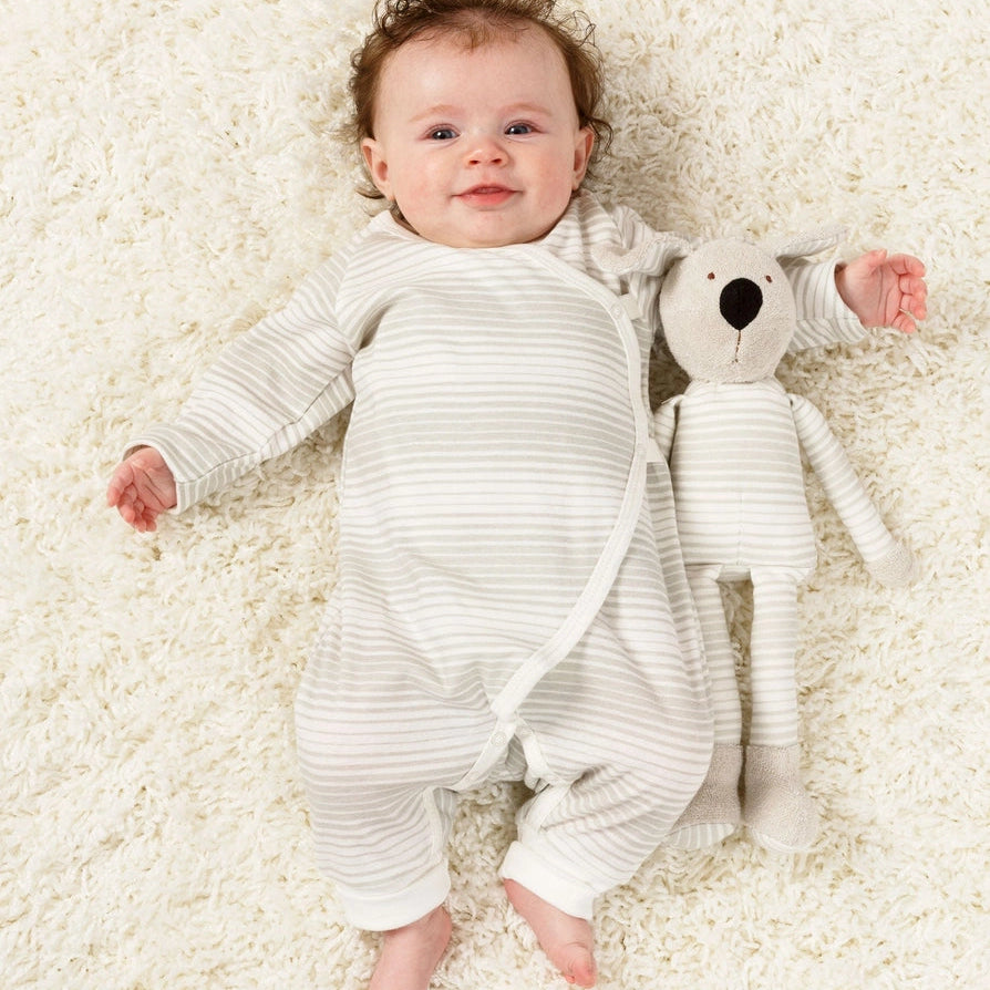 Baby with a large floppy organic toy dog