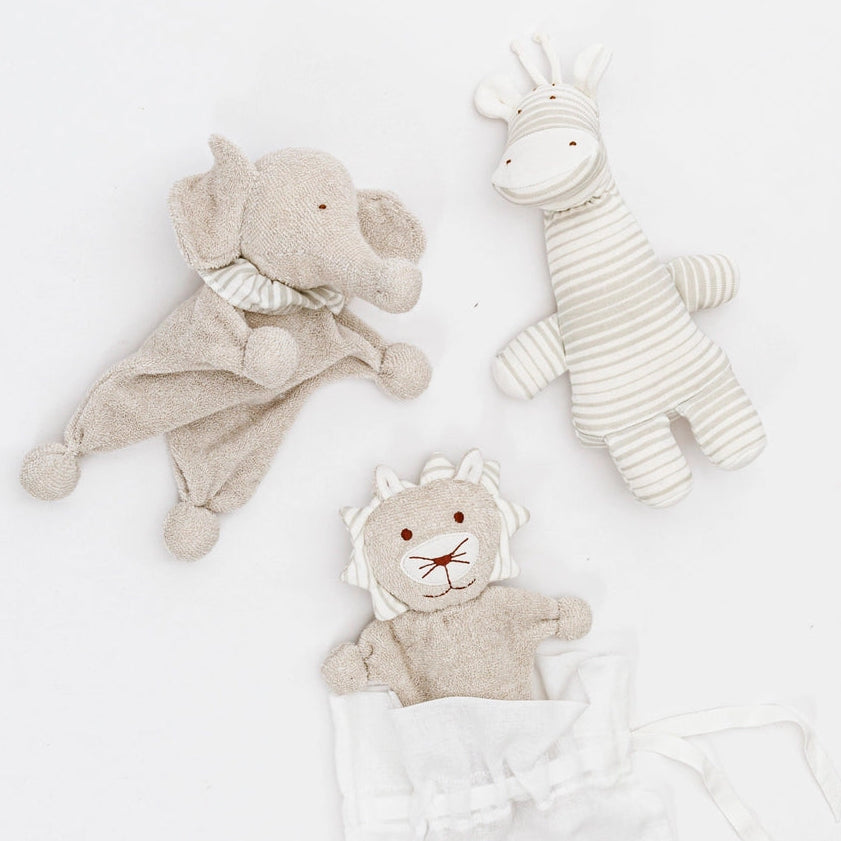 Three Under the Nile organic soft baby toys, including an elephant, a lion, and a giraffe.