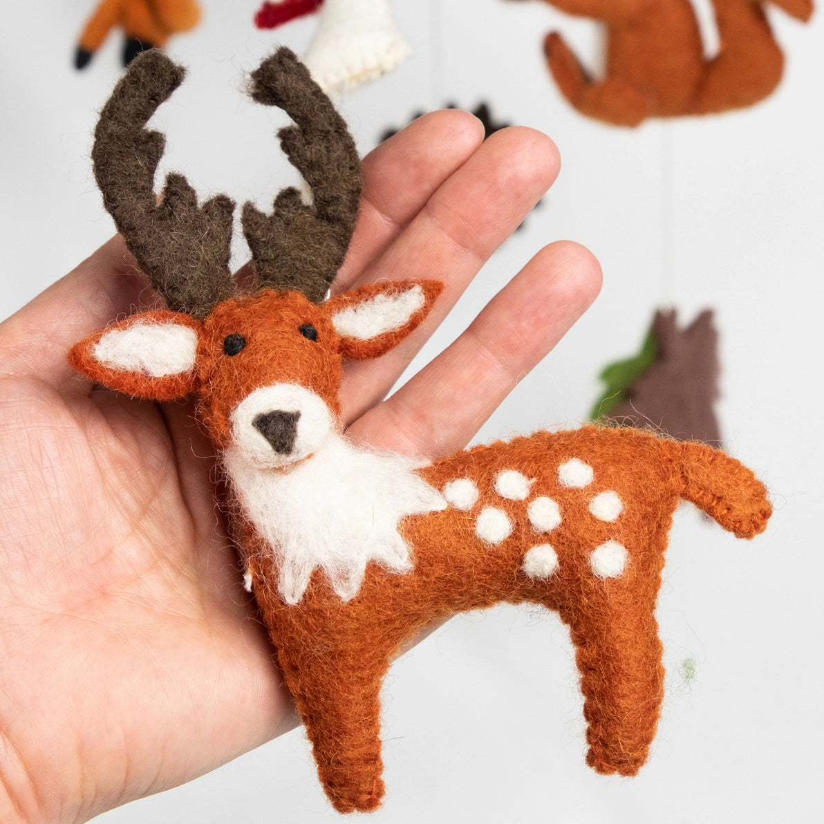 Hand holding a felt deer 