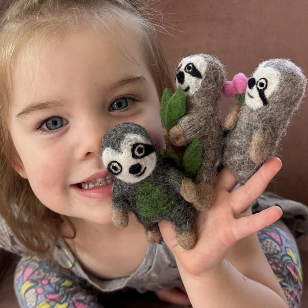 girl playing with felt sloth finger puppets