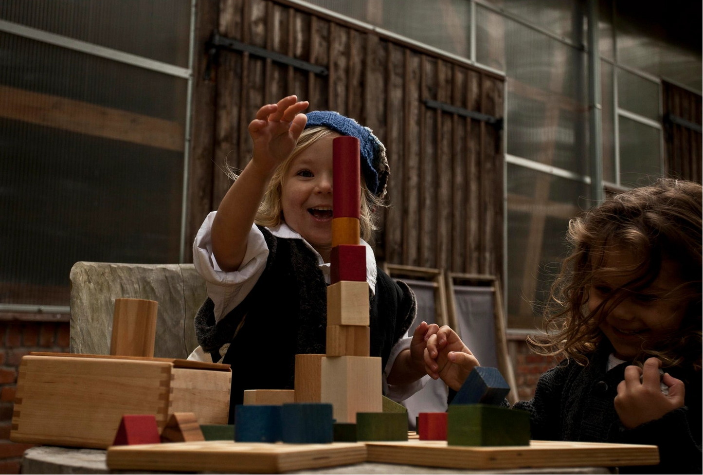 Child playing with wooden story rainbow building blocks