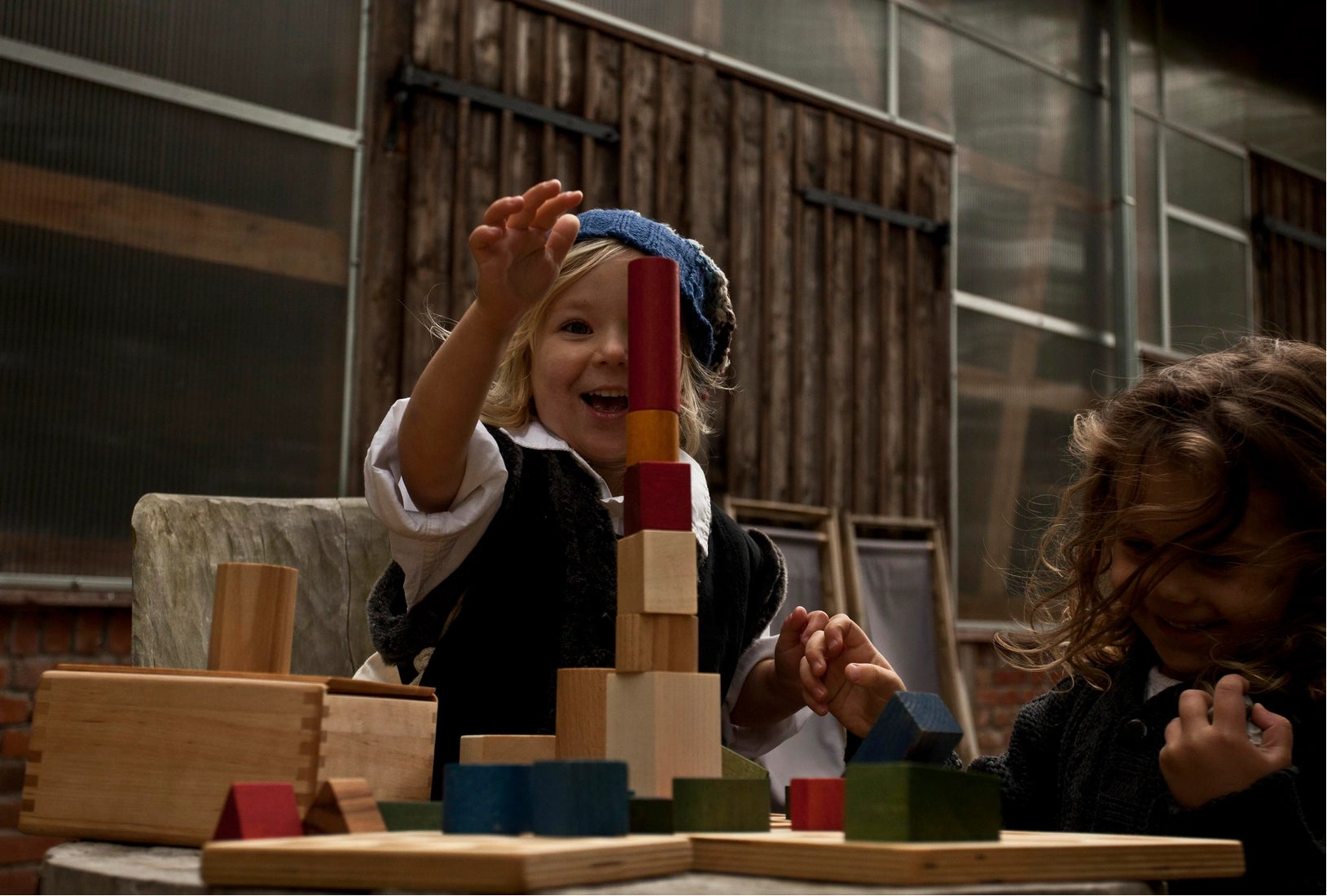 Child playing with wooden story rainbow building blocks