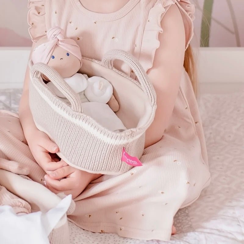 Girl holding knitted basket and baby doll