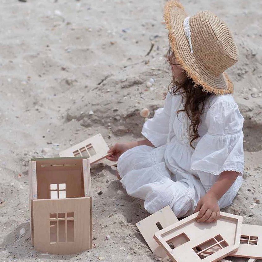 girl building wooden dollhouse