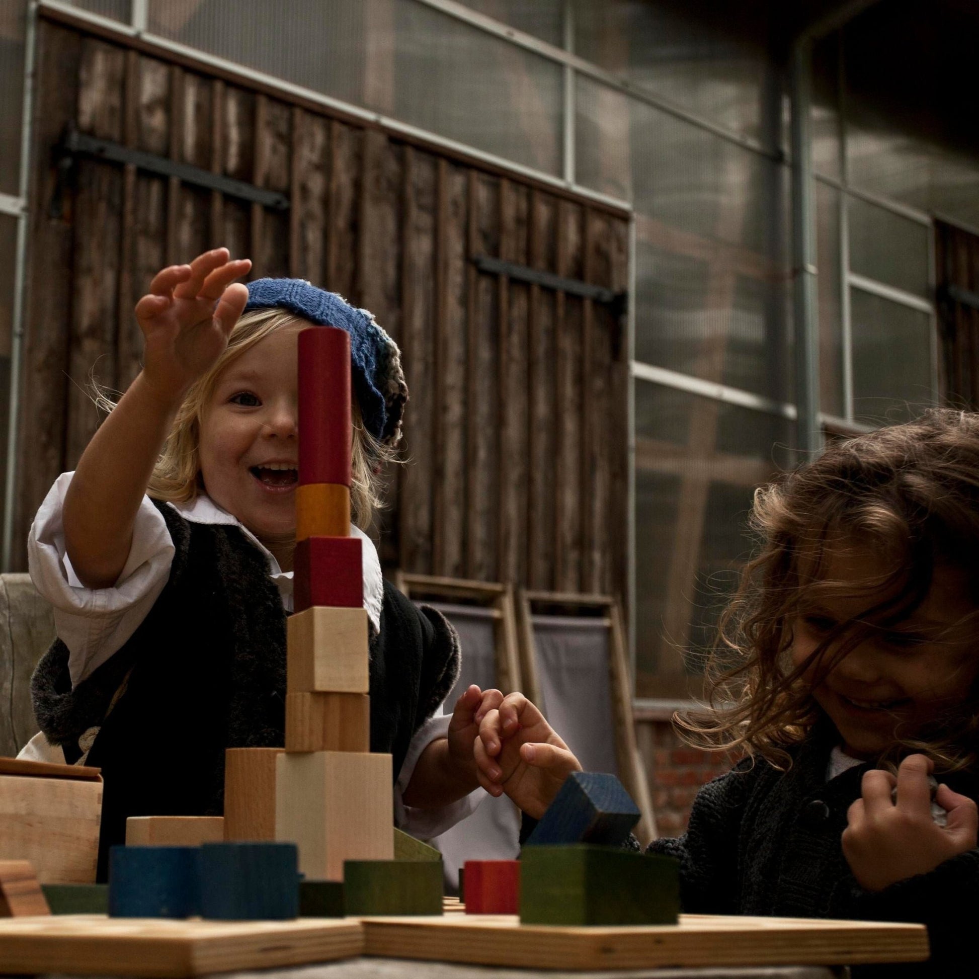 kids playing with heirloom wooden rainbow blocks