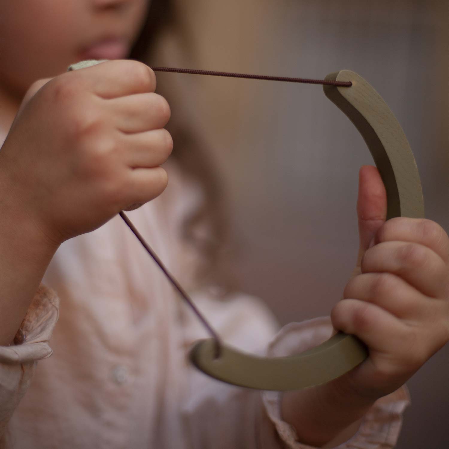 girl with wooden slingshot toy
