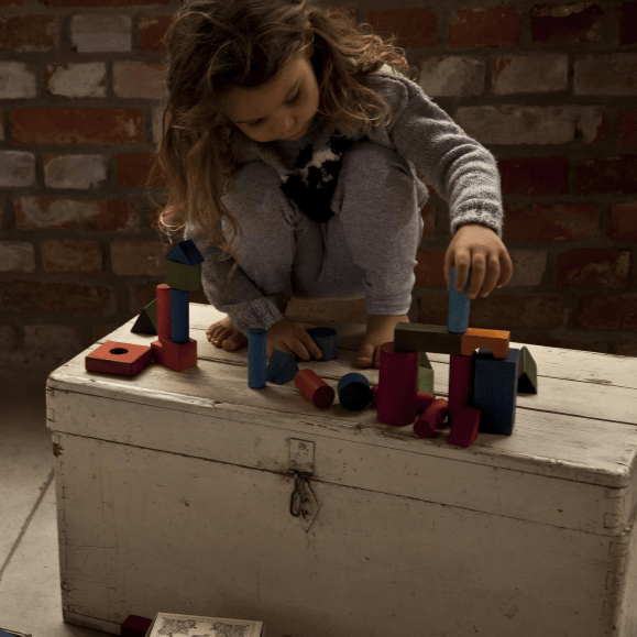 girl playing with heirloom wooden block toys