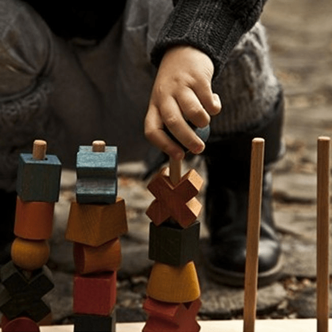 boy stacking and sorting wooden shapes